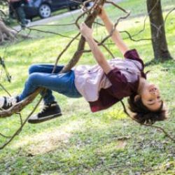 Little boy climb on a tree rope